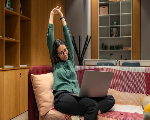 woman doing yoga stretching exercises at home for wellness